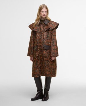 Cappotto marrone a fantasia con un ampio colletto arricciato e due tasche frontali. Accentuato con dettagli in pelle marrone scuro e indossato con stivali marroni.