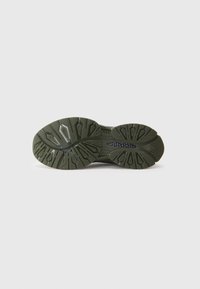 Groene rubberen schoenzool met een gestructureerd grippatroon, met duidelijke noppen en vormen voor grip en duurzaamheid.