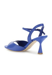 Siniset nahkasaappaat korolla, joissa on avoton malli, säädettävä nilkkaremmii ja levenevä korko. Sileä pinta kiiltävällä viimeistelyllä.