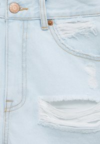 Světle modré vyšisované džíny s roztrženými dírami, s běžnými poutky na pásek, měděnými nýty a kontrastními švy.