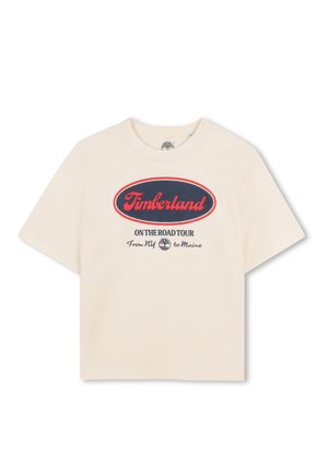 T-shirt en coton de couleur crème à manches courtes. Présente un grand graphique ovale rouge et marine avec l'inscription "Timberland On The Road Tour".