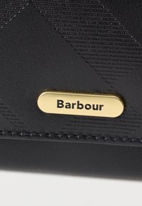 Must-haves musta tekstuuriga must rahakott diagonaalse mustriga, millel on kuldne metallist brändinguplaat, millel on graveeritud "Barbour". Kvaliteetne materjal ja delikaatne õmblusdetail.