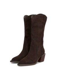 Botas de vaquero de ante marrón con punta afilada, caña alta y tacón de madera apilada. Textura suave sin patrones visibles ni herrajes.