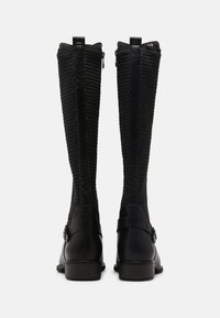 Botas negras hasta la rodilla con un panel de rejilla y cuero suave, que cuentan con un cierre lateral, un acento de hebilla y un diseño texturizado en la parte superior.