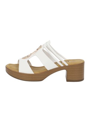 Sandale blanche à bout ouvert avec un design découpé, des brides réglables et des accents métalliques décoratifs. Dispose d'un talon carré texturé marron.