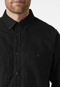 Zwarte button-up shirt van katoen, met een puntige kraag, twee borstzakken en bijpassende knopen. Glad textuur, eenvoudige ontwerp.
