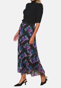 Black floral maxi skirt with purple and teal patterns, lightweight fabric, smocked waistband, paired with a fitted black top and black heels.