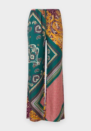 Pantalon large ample avec un imprimé patchwork paisley et géométrique en vert, moutarde, bordeaux et rouge, doté d'une taille élastique et d'un cordon de serrage.