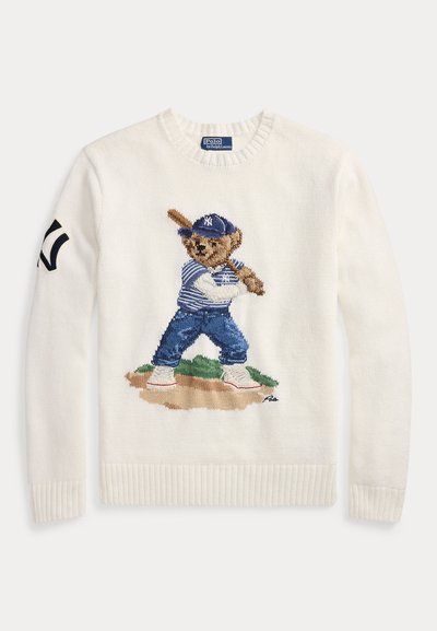 Λευκό πλεκτό πουλόβερ με κέντημα αρκούδας ντυμένης με στολή μπέιζμπολ, κρατώντας ένα ρόπαλο. Διαθέτει ριμπ μανσέτες και λαιμόκοψη.