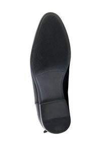Suela de zapato negra con goma texturizada para agarre, con punta redondeada suave y un tacón bajo y cuadrado para mayor estabilidad.