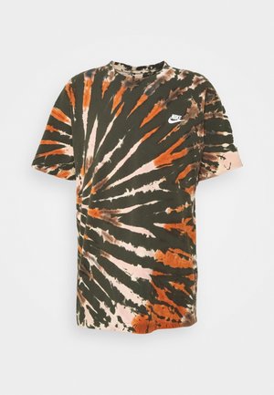 Koszulka Nike z krótkim rękawem z pomarańczowo-czarnym i beżowym wzorem tie-dye w formie spirali oraz białym logo Nike na piersi.