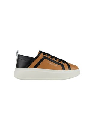 Low-top sneaker met een bovenkant van bruin en zwart leer, dikke witte zool, zwarte veters en een hieltreklip.