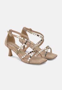 Sandalias de ante nude con punta cuadrada y un tacón de bloque de 5 cm. Presentan correas entrelazadas adornadas con acentos espejados.