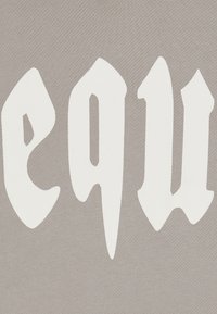 Tessuto grigio con grande e audace testo bianco caratterizzato da elementi di design appuntiti e angolari e un aspetto texturizzato. Nessun ulteriore motivo o accento.