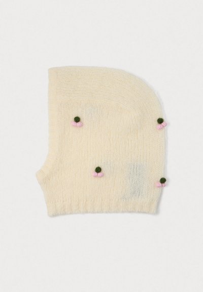 Balaclava di colore crema lavorata a maglia con piccoli gruppi di pompon verdi e rosa distribuiti uniformemente sul tessuto.
