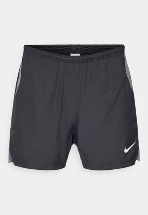 Shorts de sport noirs avec un panneau latéral en mesh et une taille élastique. Logo blanc sur le bas à l'avant. Tissu léger.