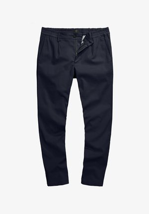 Granatowe spodnie z mieszanki bawełny o luźnym kroju, elastycznym pasie, zapięciem na guzik i zamkiem błyskawicznym. Gładka tekstura bez widocznych wzorów.