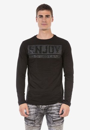 Black long-sleeve t-shirt featuring raised black letters spelling "ENJOY" on a textured panel across the chest. Smooth fabric finish.