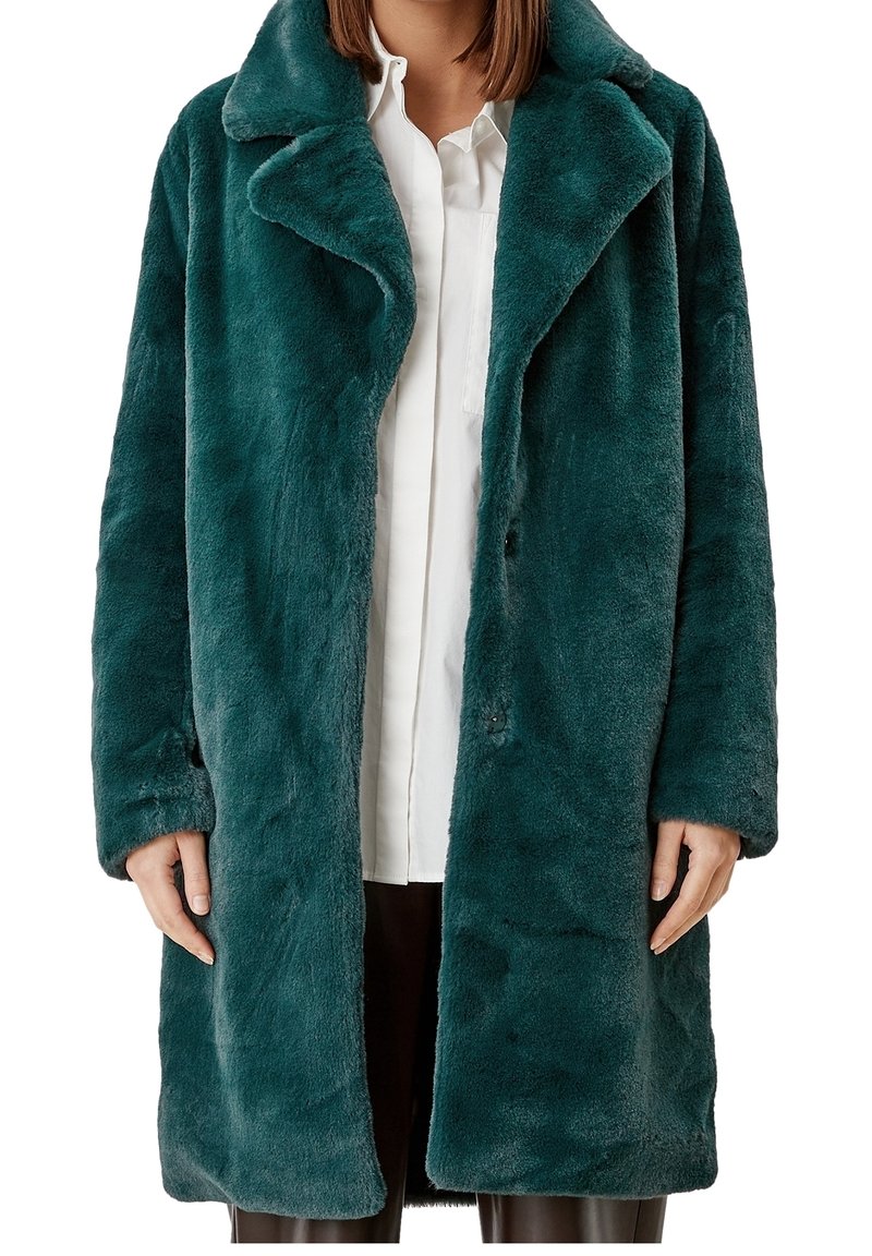 Futro syntetyczne w głębokim odcieniu teal. Posiada wycięty kołnierz, guziki z przodu i boczne kieszenie, charakteryzuje się miękką teksturą i luźnym krojem.