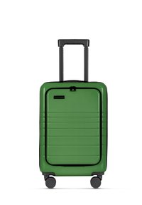 Groene hard-shell koffer met een gestructureerd oppervlak, horizontale groeven, zwarte ritsaccenten, telescopische handgreep en vier zwarte wielen.