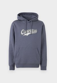 Σκούρα γκρι φούτερ Converse με μπροστινή τσέπη, κουκούλα με ρυθμιζόμενο κορδόνι και λευκό λογότυπο στο στήθος, σε απλό φόντο.