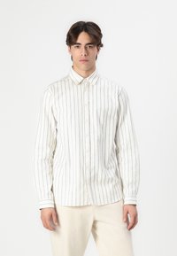 Langermet skjorte med knapper i off-white som har svarte vertikale striper, kragedesign og mansjetterte ermer, laget av myk stoff.