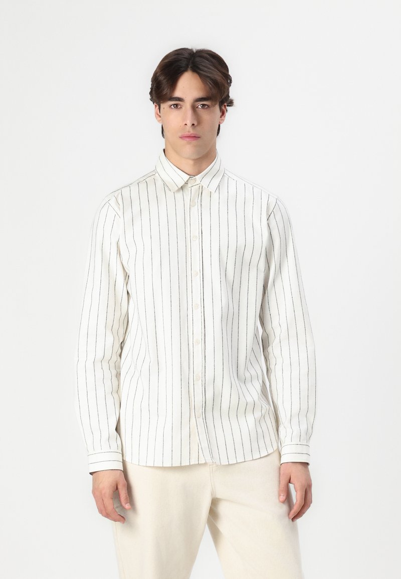 Langermet skjorte med knapper i off-white som har svarte vertikale striper, kragedesign og mansjetterte ermer, laget av myk stoff.