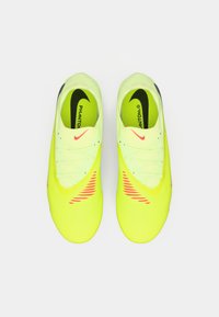 Neon żółte korki piłkarskie z teksturowanym wierzchem, smukłym designem i czerwonymi akcentami. Posiadają sznurówki oraz logo Nike na wkładce.