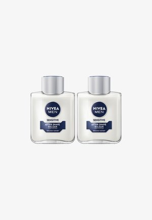 Zwei klare Kunststoffflaschen mit NIVEA Men Sensitive After Shave Balsam. Jede hat einen silbernen Deckel und eine weiße Cremetextur. Die Etiketten sind blau und weiß.