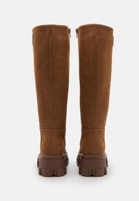 Knee-high brązowe zamszowe botki o teksturowanym wykończeniu, płaskiej brązowej gumowej outsole i bocznych zamkach błyskawicznych dla łatwego zakładania.