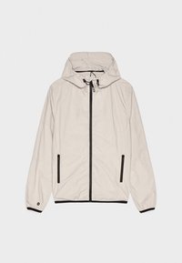 Ljusbeige hujacka med dragkedja framtill och svarta detaljer, utrustad med sidosfickor och elastiska muddar. Slät textur, avslappnad design.