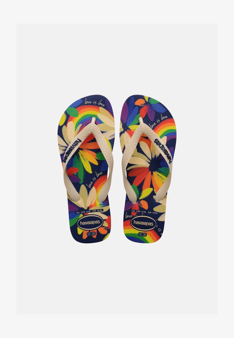 Fehér pántos Havaianas papucsok párosa, színes virágos és szivárvány mintával, valamint "love is love" felirattal a sötétkék talpon.