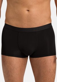 Black boxer briefs made of smooth fabric with a fitted design, featuring a wide waistband embossed with the brand name "HANRO."
