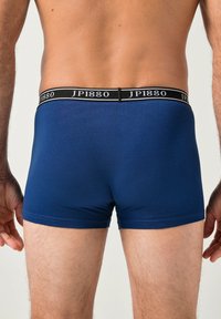 Bóxers azul marino hechos de tela suave, con una cintura negra que lleva el logo "JP1880". El ajuste es ceñido, con costuras mínimas.