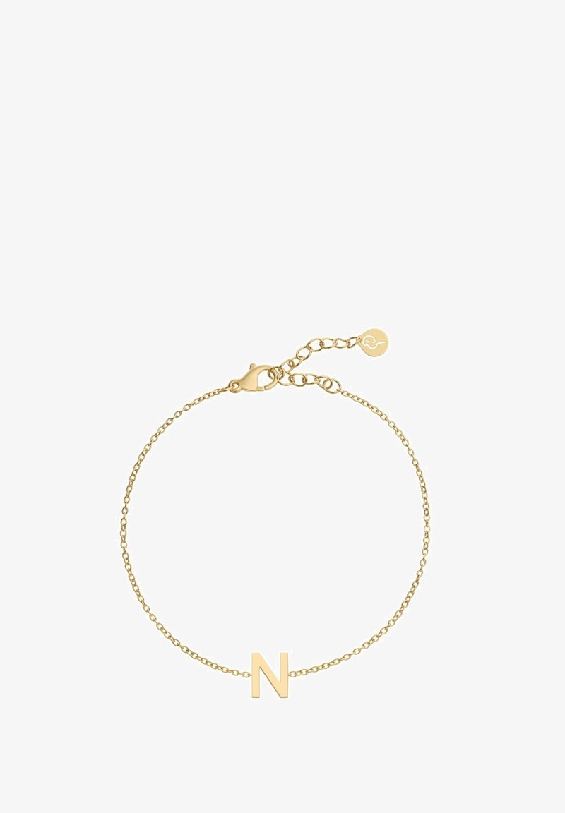 Kuldne käevõru, millel on üksik täht "N" ripats. Ahel on õhuke, varustatud klambri sulguri ja reguleeritava pikkusega, et sobida erinevatele suurustele.