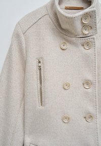 Beige wollen blend peacoat met een gestructureerd ruitpatroon, dubbele knopen, een hoge kraag en een ritszak aan de linkerkant.