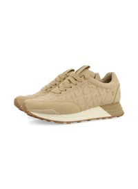 Zapatos deportivos beige con parte superior texturizada, que presenta un diseño estampado. La suela es ligeramente elevada y cuenta con una suela de goma ligera.