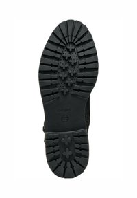 Suela de zapato de goma negra con surcos profundos, que presenta patrones circulares y en forma de cruz. Marca Geox visible. Superficie texturizada para mayor agarre.