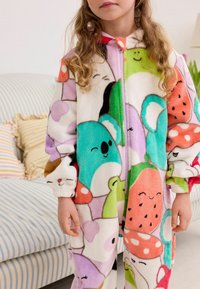 Combinaison en polaire avec un design coloré d'animaux souriants et de fruits, dotée d'une fermeture éclair à l'avant et de poignets ajustés, dans des tons pastel.