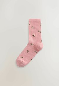 Șosetă roz din bumbac, cu manșetă striată și modele mici florale în verde și alb. Forma este standard, cu un design fără cusături la vârf.