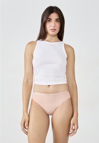 Lekki biały top na ramiączkach w połączeniu z gładkimi różowymi majtkami bikini z błyszczącym elastycznym pasem. Prosty i minimalistyczny design.