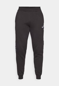 Zwarte sweatpants gemaakt van zachte stof, met een geribde tailleband, taps toelopende benen en zijaccenten met logodetails.