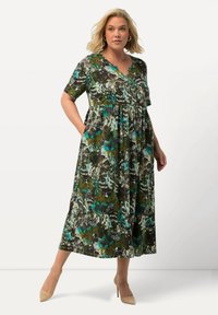 Kurzes ärmelloses, knöchellanges Kleid mit einem mehrfarbigen Blumenmuster, lockerer Passform, V-Ausschnitt und seitlichen Taschen. Hergestellt aus einem leichten Stoff.