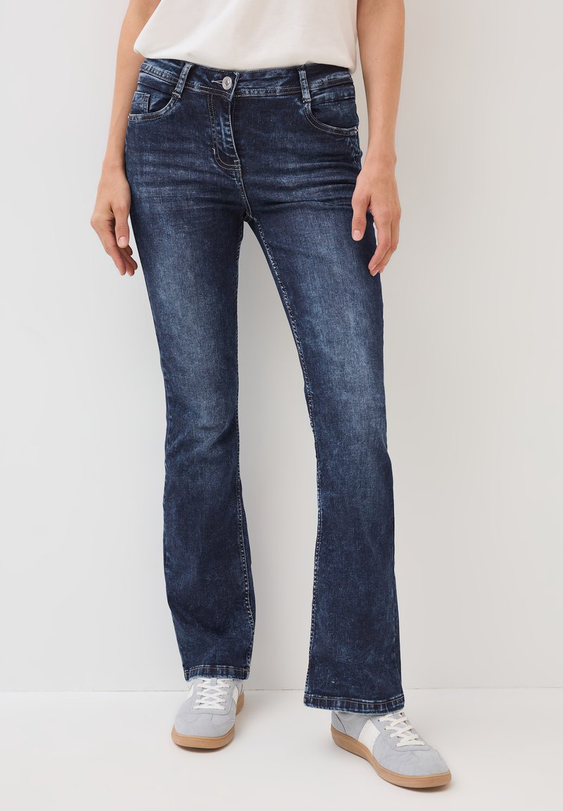Donkerblauwe wijde jeans van denim, met voorzakken, een rits en contrasterende stiksels langs de naden en zakken.