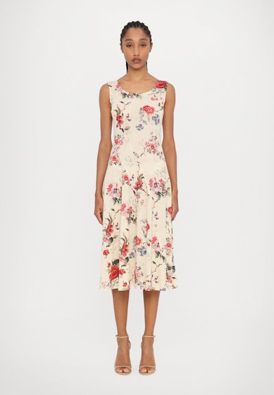Robe midi florale en crème, avec un décolleté en cœur et une jupe évasée ornée de motifs floraux roses et bleus. Texture de tissu lisse.
