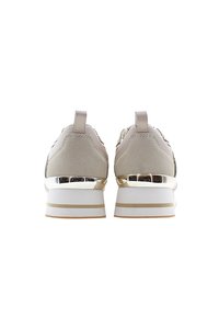 Paire de baskets à plateforme beige et blanche avec des accents dorés métalliques, vues de dos sur fond blanc.