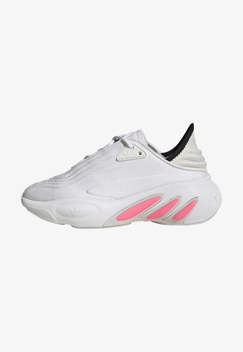 White athletic shoe with textured mesh upper, a black heel, and pink accents on the rubber sole featuring three distinct grooves.