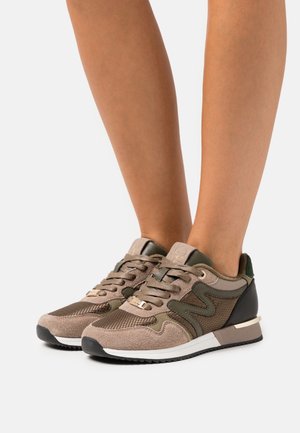 Scarpe sportive con una miscela di suede marrone e mesh, caratterizzate da dettagli verdi, un tallone nero e accessori in oro. Design leggero con una finitura testurizzata.