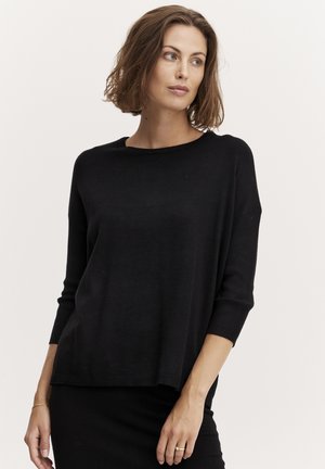 Pull en maille noir à coupe décontractée, manches 3/4 et encolure ronde, avec une texture lisse et un design simple.