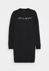 Vestito felpa nero in tessuto morbido, con maniche lunghe e scollo arrotondato. Sul davanti presenta testo bianco scritto a mano.